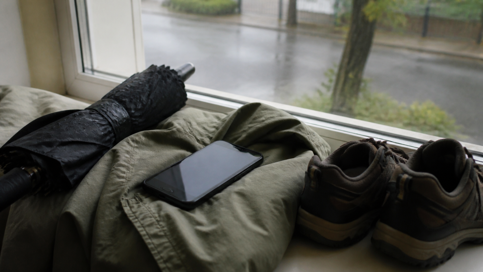 Weather forecast widget beside a window with a changing sky and umbrella